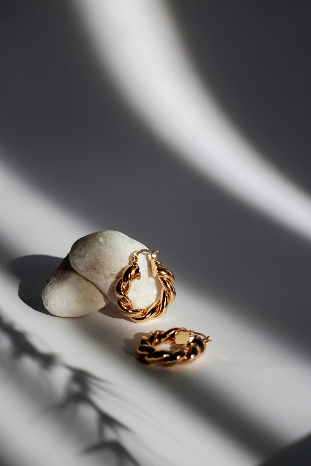 Temporary close-up placeholder of sculptural gold hoop earrings.